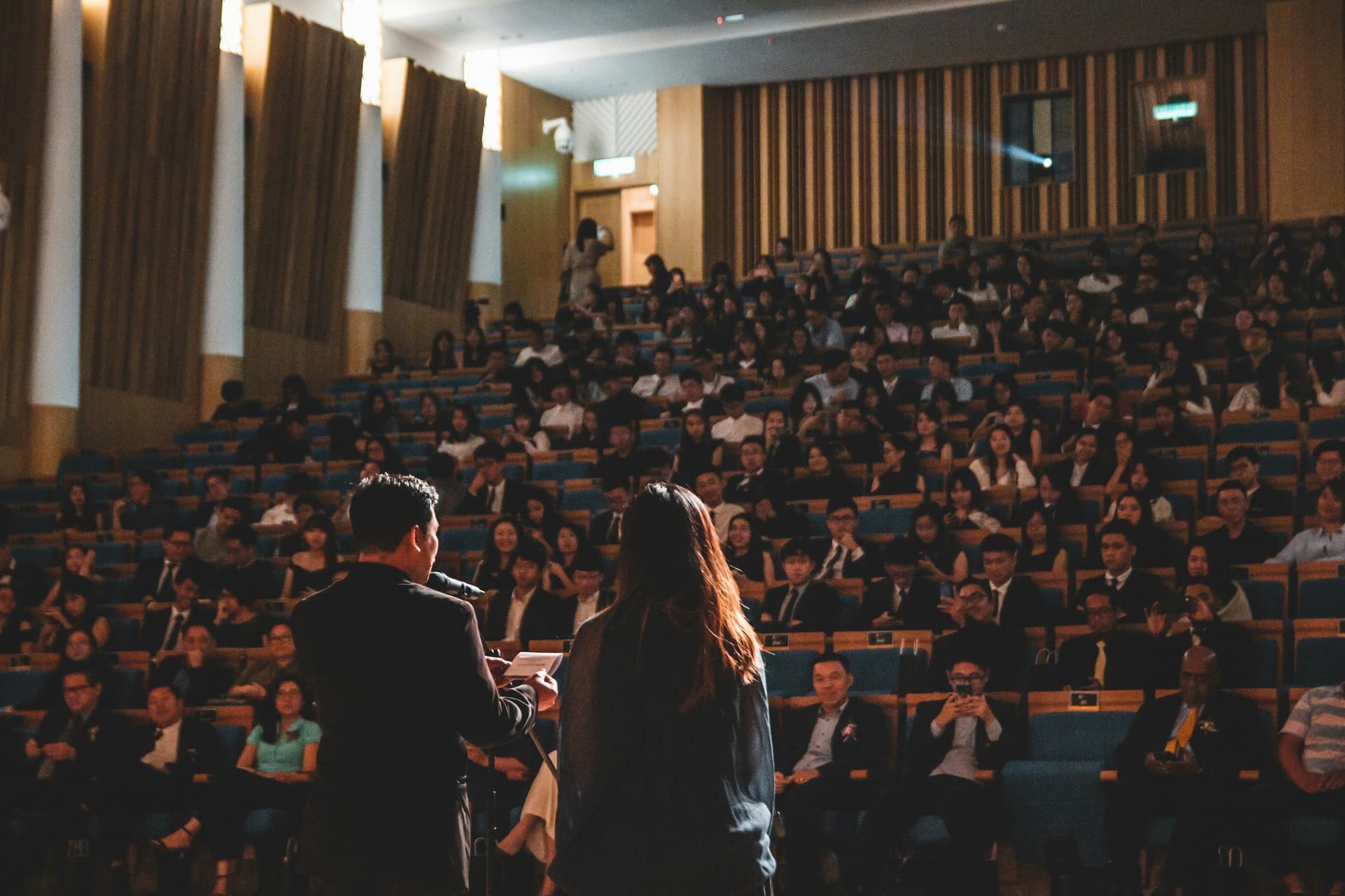 Conference speakers presenting to a seated audience